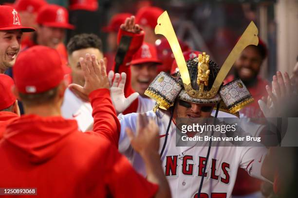 Mike Trout gets high fives in the dugout after blasting a two-run homer on his first pitch as the Angels play the Blue Jays at Angel Stadium of...