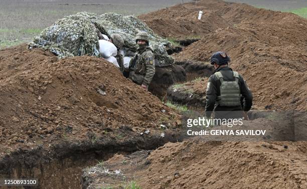Ukrainian servicemen stand at their position in trenches near the town of Bakhmut, Donetsk region on April 8 amid the Russian invasion of Ukraine. -...