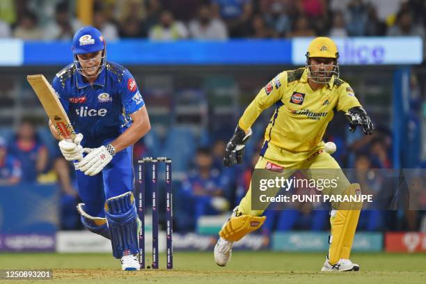 Mumbai Indians' Cameron Green plays a shot as Chennai Super Kings' captain Mahendra Singh Dhoni watches during the Indian Premier League Twenty20...