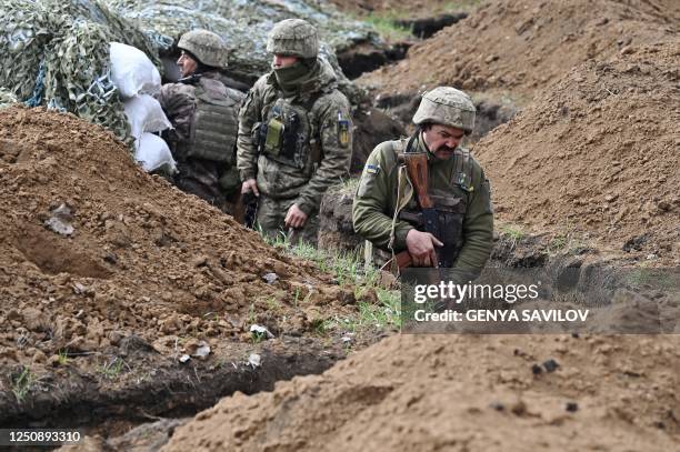 Ukrainian servicemen stand in a trench near their position near the town of Bakhmut, Donetsk region on April 8 amid the Russian invasion of Ukraine....