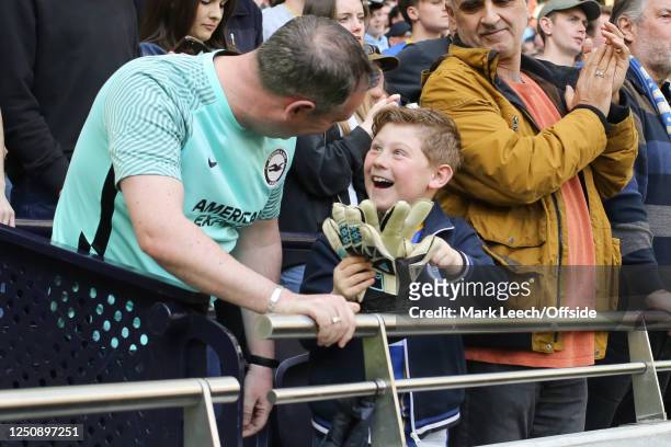 A happy young fan receives the gloves from Brighton & Hove Albion goalkeeper Jason Steele after the Premier League match between Tottenham Hotspur...