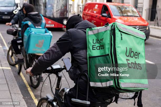 Uber Eats and Deliveroo takeaway delivery cycle couriers on 30th March 2023 in London, United Kingdom. Uber Eats is an online food ordering and...