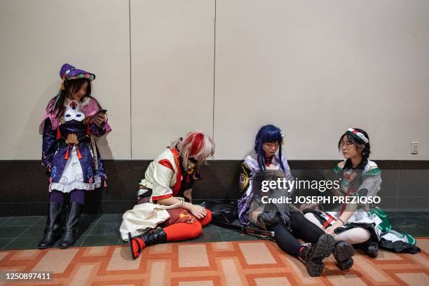 Group of cosplayers take a break from the convention floor and rest in a hallway at Anime Boston in Boston, Massachusetts, on April 8, 2023. - The...