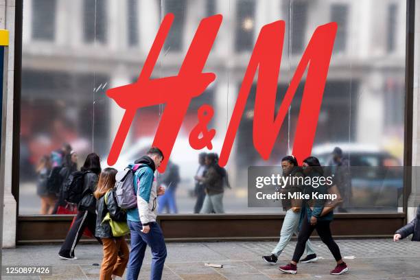 People passing a large scale sign for the high street clothes and clothing brand H&M outside their flagship store on the corner of Oxford Street and...