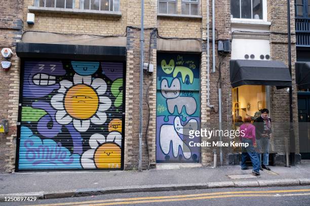 Street art by various artists on shutters outside a boutique shop in Hoxton on 6th March 2023 in London, United Kingdom. Street art in the East End...