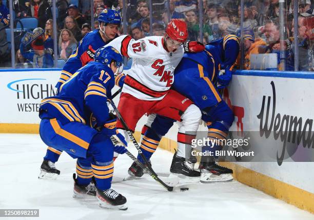 Jesperi Kotkaniemi of the Carolina Hurricanes battles for the puck against Tyson Jost of the Buffalo Sabres during an NHL game on April 8, 2023 at...