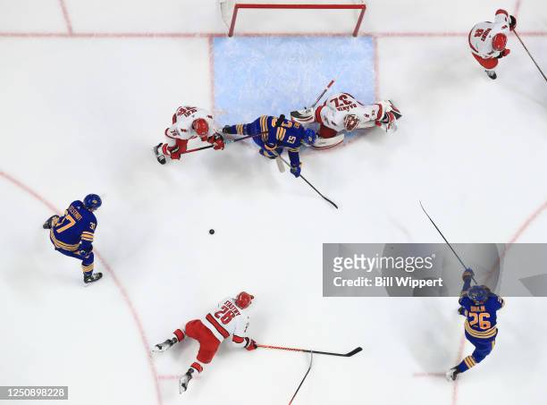 Rasmus Dahlin of the Buffalo Sabres drops a pass to Casey Mittelstadt prior to him scoring during an NHL game against the Carolina Hurricanes on...