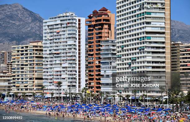 Holidaymakers crowd Levante Beach in Benidorm on April 8, 2023. - The hotel occupancy rate in the seaside resort of Benidorm reached 95% during the...