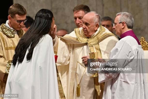 Pope Francis gives the communion to a freshly baptised woman, during the Easter Vigil mass on April 8, 2023 at St. Peter's basilica in The Vatican,...