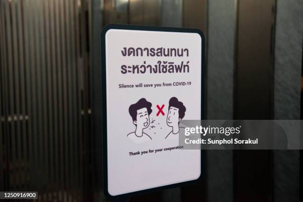 signage informing people to avoid talking in an elevator - social distancing elevator stock pictures, royalty-free photos & images