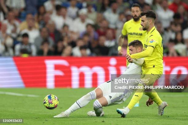 Real Madrid's Uruguayan midfielder Federico Valverde vies with Villarreal's Spanish midfielder Alex Baena during the Spanish league football match...