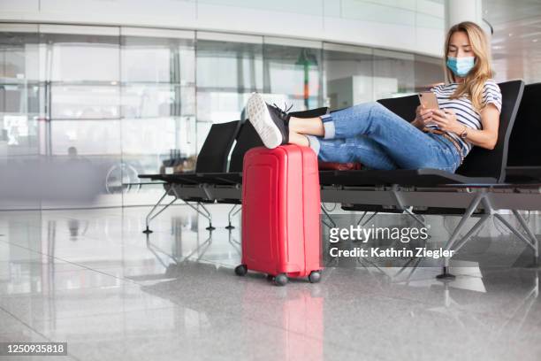woman waiting at empty departure gate, wearing protective face mask - coronavirus airport fotografías e imágenes de stock