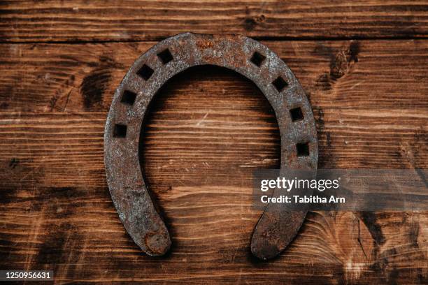 rostiges hufeisen auf holz glücksbringer aberglauben - horseshoe luck stock pictures, royalty-free photos & images