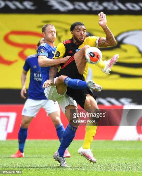 Troy Deeney of Watford is challenged by Jonny Evans of Leicester City during the Premier League match between Watford FC and Leicester City at...