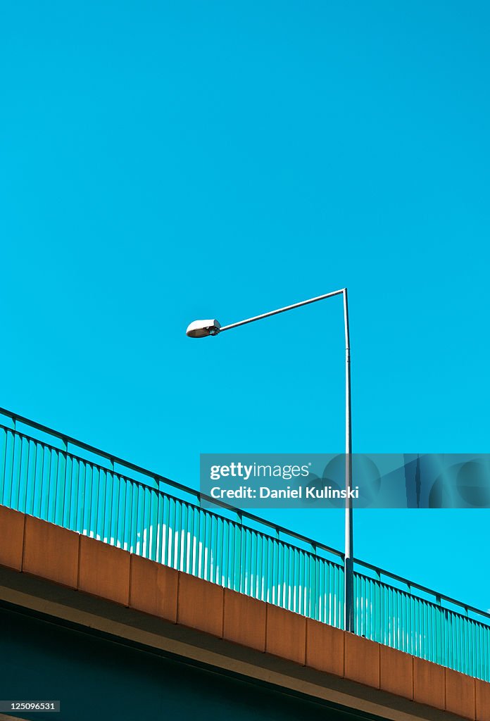 Street lamp  over bridge against blue sky