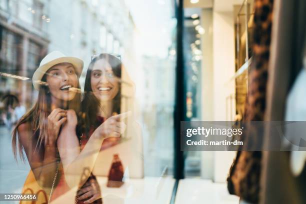 meisjes op het winkelen - etalages kijken stockfoto's en -beelden