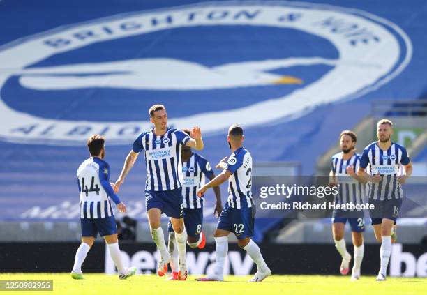 Lewis Dunk of Brighton and Hove Albion celebrates with Aaron Connolly and Martin Montoya after scoring his team's first goal during the Premier...