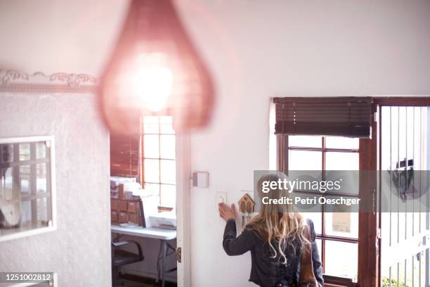 a small business owner turning on the lights in her shop. - turn off light stock pictures, royalty-free photos & images