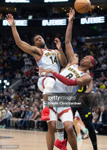 Peyton Watson and Ish Smith of the Denver Nuggets collide as they try to grab a rebound against the Utah Jazz during the second half of their game...