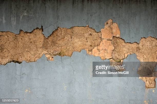crumbling concrete stucco building exterior wall with peeling weathered light grey paint - deterioration stock pictures, royalty-free photos & images