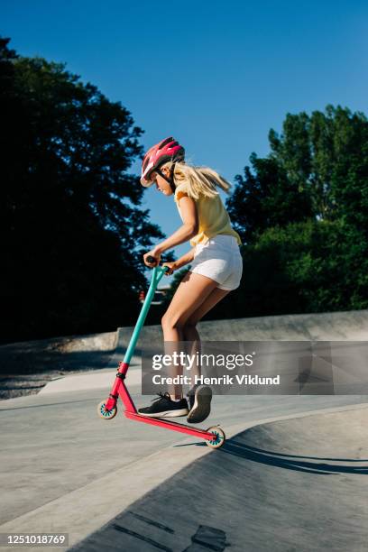 young girl riding scooter in skate park - girl riding scooter stock pictures, royalty-free photos & images