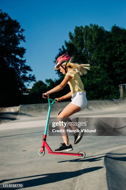 young girl riding scooter in skate park - girl riding scooter stock pictures, royalty-free photos & images