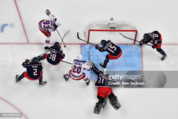 Mika Zibanejad of the New York Rangers plays the puck as goaltender Michael Hutchinson of the Columbus Blue Jackets defends the net during the first...
