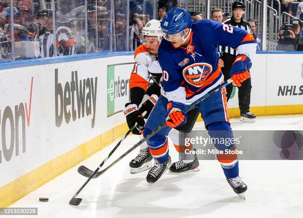 Hudson Fasching of the New York Islanders is defended by Justin Braun of the Philadelphia Flyers during the first period at UBS Arena on April 08,...