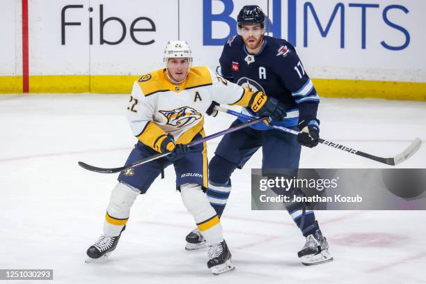 Tyson Barrie of the Nashville Predators and Adam Lowry of the Winnipeg Jets keep an eye on the play during first period action at the Canada Life...