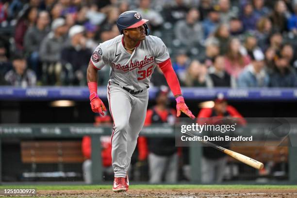 Stone Garrett of the Washington Nationals watches the flight of a third inning three run homerun against the Colorado Rockies during a game at Coors...