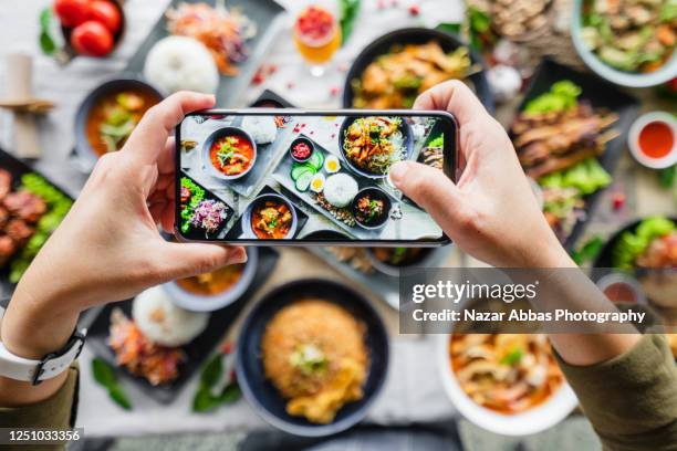 taking photo of food full table. - chicken satay stock pictures, royalty-free photos & images