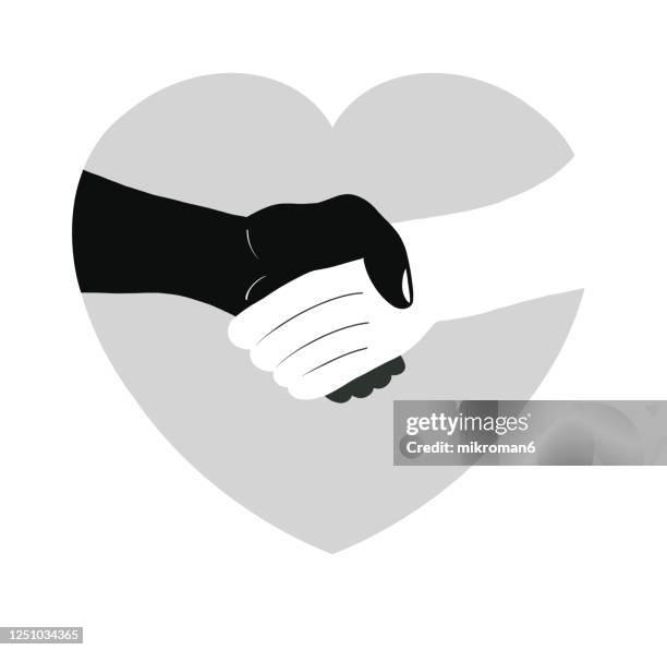 two people of different races, white and black, shaking hands - partner violence stock pictures, royalty-free photos & images