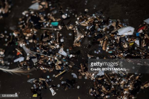 Photograph taken on February 26, 2023 shows nurdles and other micro-plastics waste collected during a beach clean organised on the Tregantle beach...