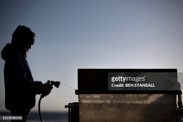 Volunteer cleans a machine used to filter nurdles and microplastics from natural waste during a beach clean on the Tregantle beach part of the...
