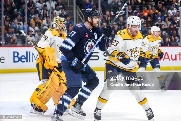 Adam Lowry of the Winnipeg Jets battles Jake Livingstone of the Nashville Predators in front of goaltender Juuse Saros as they keep an eye on the...