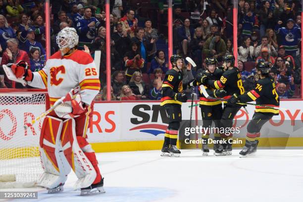 Cole McWard of the Vancouver Canucks is congratulated after scoring his first NHL goal on Jacob Markstrom of the Calgary Flames during the first...