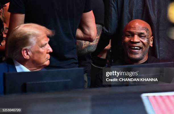 Former President Donald Trump talks with former US professional boxer Mike Tyson as they attend the Ultimate Fighting Championship 287 mixed martial...