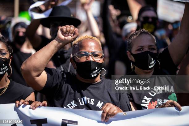 African American protesters wearing masks that say "I Can't Breathe" hold the banner for Unite NYC 2020 as they perform a peaceful protest walk...