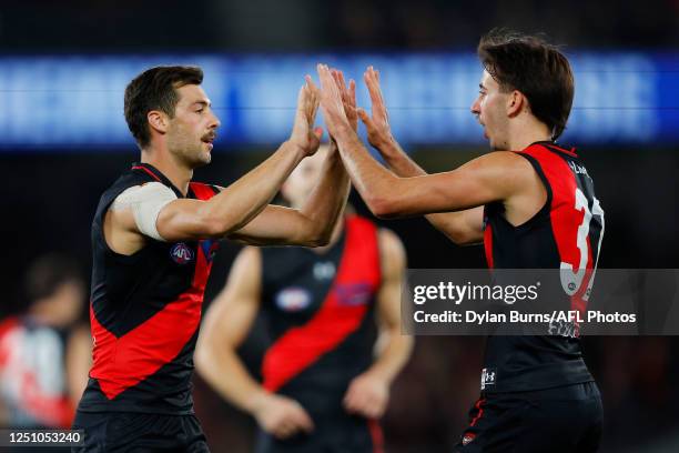 Kyle Langford of the Bombers celebrates a goal with teammate Nic Martin during the 2023 AFL Round 04 match between the Essendon Bombers and the GWS...