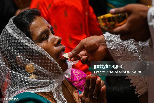 Catholic devotee receives Holy Communion on Easter Sunday at St. Anthony's church in Colombo on April 9, 2023.