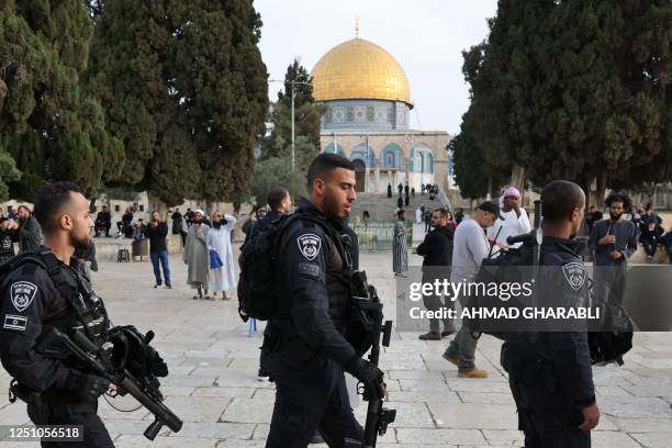 Jewish visitors walk protected by Israeli security forces at the Al-Aqsa mosque compound, also known as the Temple Mount complex to Jews, in...