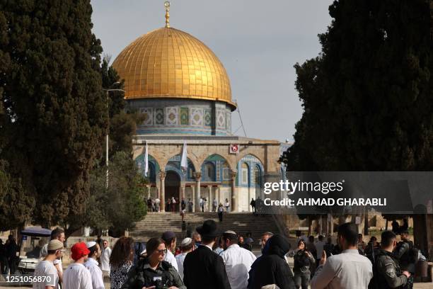 Jewish visitors walk protected by Israeli security forces at the Al-Aqsa mosque compound, also known as the Temple Mount complex to Jews, in...