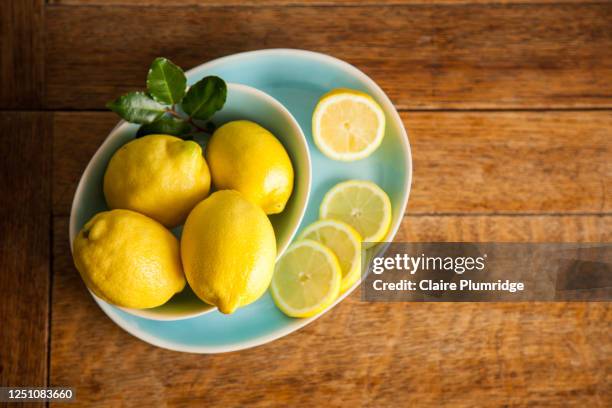 overhead view of lemons in a bowl on a wooden table - plate set stock pictures, royalty-free photos & images