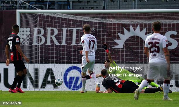 Robin Hack of 1. FC Nuernberg scores his team's first goal, Benedikt Roecker of SV Wehen-Wiesbaden, goalkepper Heinz Lindner of SV Wehen-Wiesbaden...