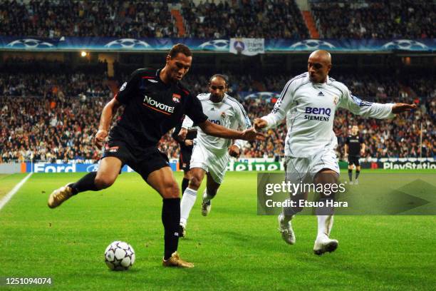 John Carew of Olympique Lyonnais and Roberto Carlos of Real Madrid compete for the ball during the UEFA Champions League Group E match between Real...