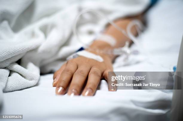 girl patient with iv drip medicine attached in hospital - enfermedad fotografías e imágenes de stock