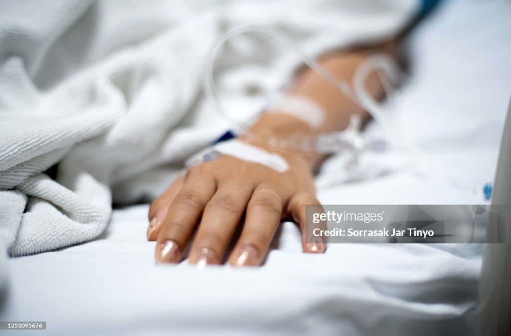 Girl patient with IV drip medicine attached in hospital
