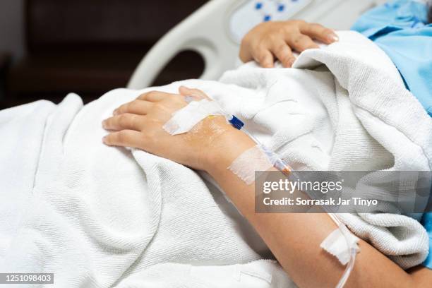 close up of patient hand receiving iv drip in the hospital bed - bloody death stock pictures, royalty-free photos & images