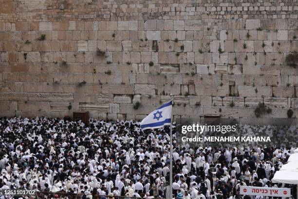 Jewish men, wearing traditional Jewish prayer shawls known as Tallit, take part in the Cohanim prayer during the Passover holiday at the Western Wall...