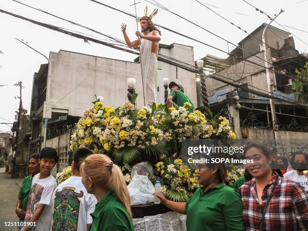 Devotees pulling the carriage of the Risen Christ during the procession at Barangay Tañong. Salubong is a pre-dawn reenactment meeting of the two...